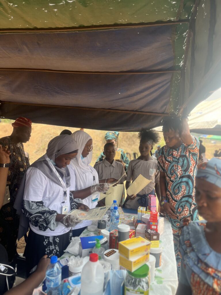 Health workers and OAKonsult volunteers preparing medical outreach support under a canopy