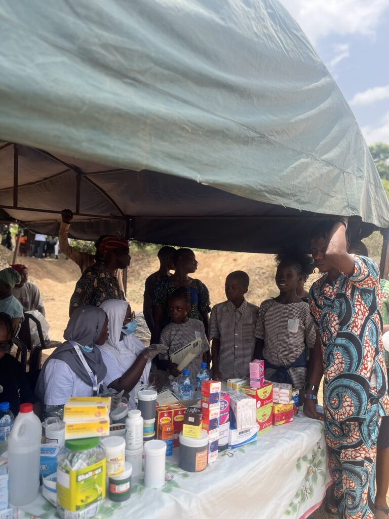 A wider view of the OAKonsult medical outreach station with supplies and volunteers